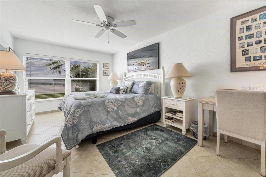 6154 Midnight Pass Road, Unit 104 Sarasota, FL 34242 - Photo 7 of 11 a bedroom with a bed a table and chair