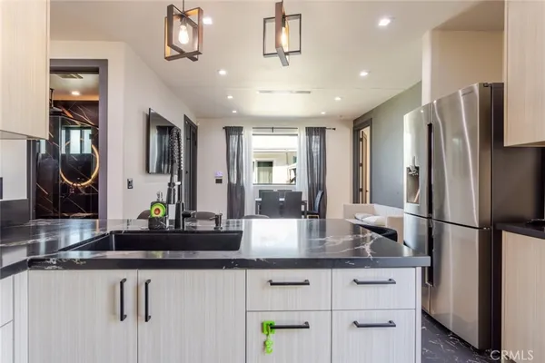 a kitchen with stainless steel appliances granite countertop a refrigerator and a sink