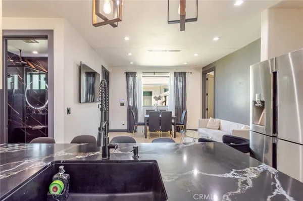 a kitchen with stainless steel appliances granite countertop a sink refrigerator and cabinets