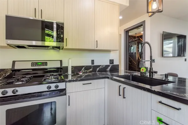 a kitchen with stainless steel appliances granite countertop a sink a stove and microwave