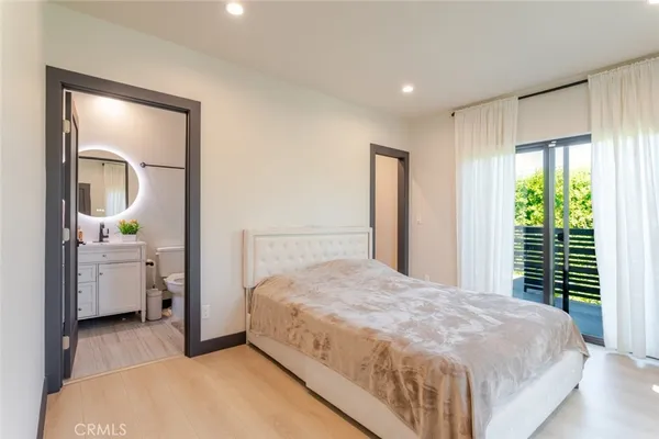 a spacious bedroom with a large bed and a mirror