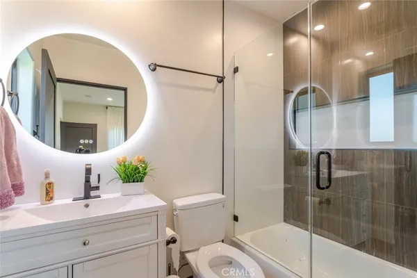 a bathroom with a sink a toilet and shower