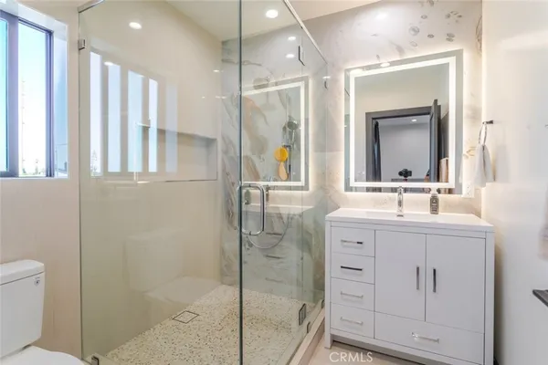 a bathroom with a double vanity sink mirror and shower