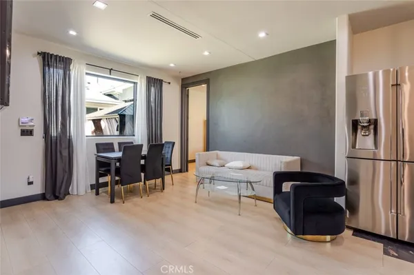 a living room with furniture and a refrigerator