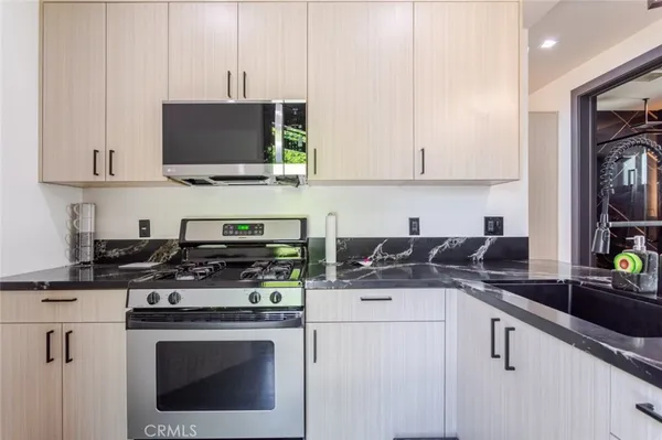 a kitchen with stainless steel appliances a stove a sink a stove and a microwave