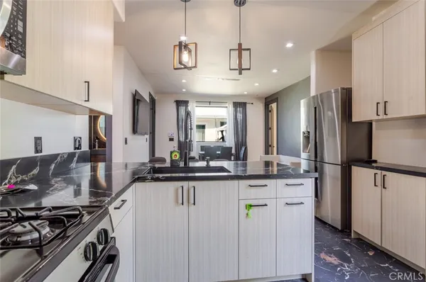 a kitchen with stainless steel appliances granite countertop a stove a refrigerator and a sink