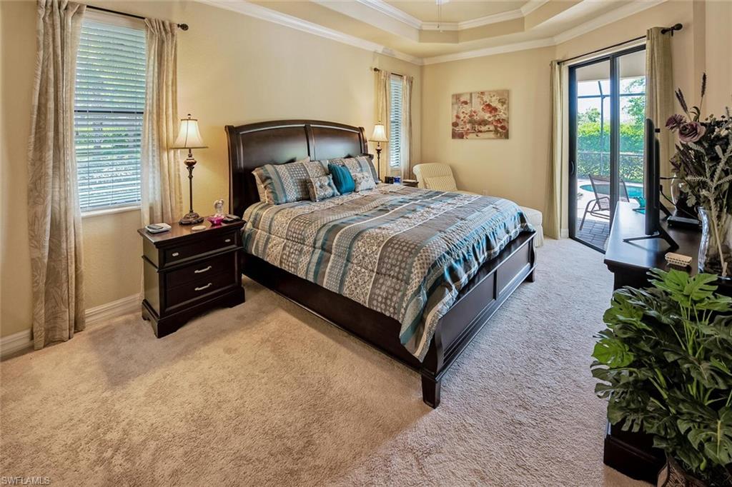 9415 Piacere Way Naples, FL 34113 - Photo 12 of 35 a spacious bedroom with a bed a couch and a large window