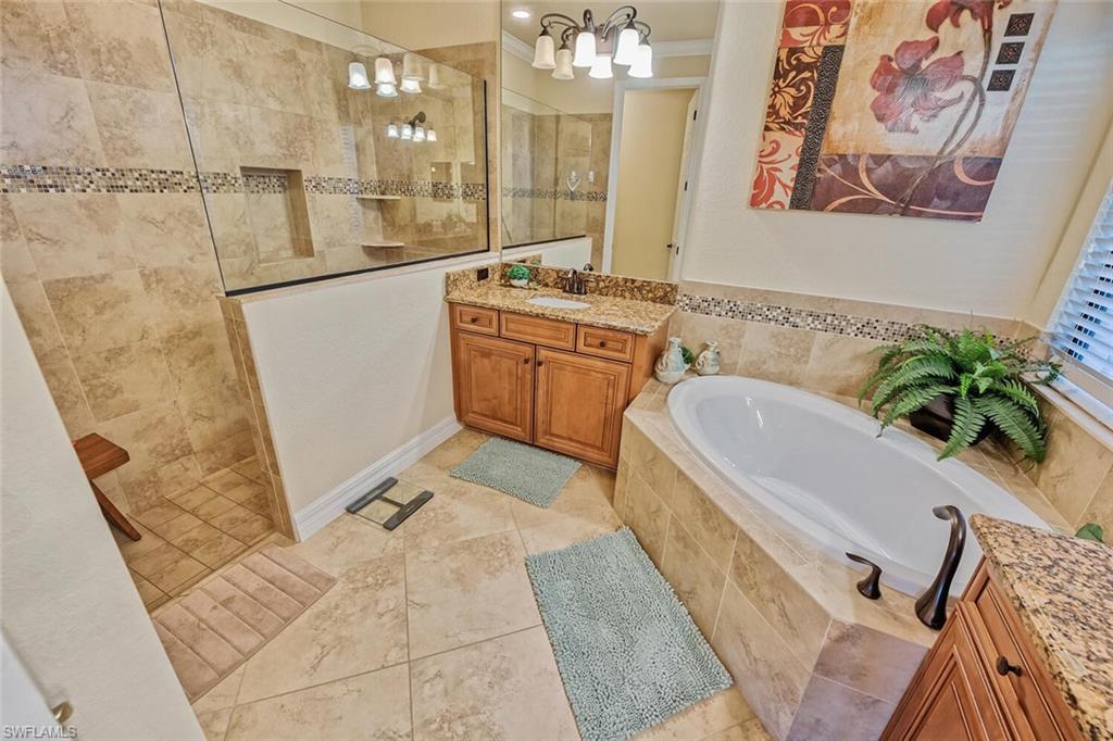 9415 Piacere Way Naples, FL 34113 - Photo 14 of 35 a spacious bathroom with a tub sink and mirror