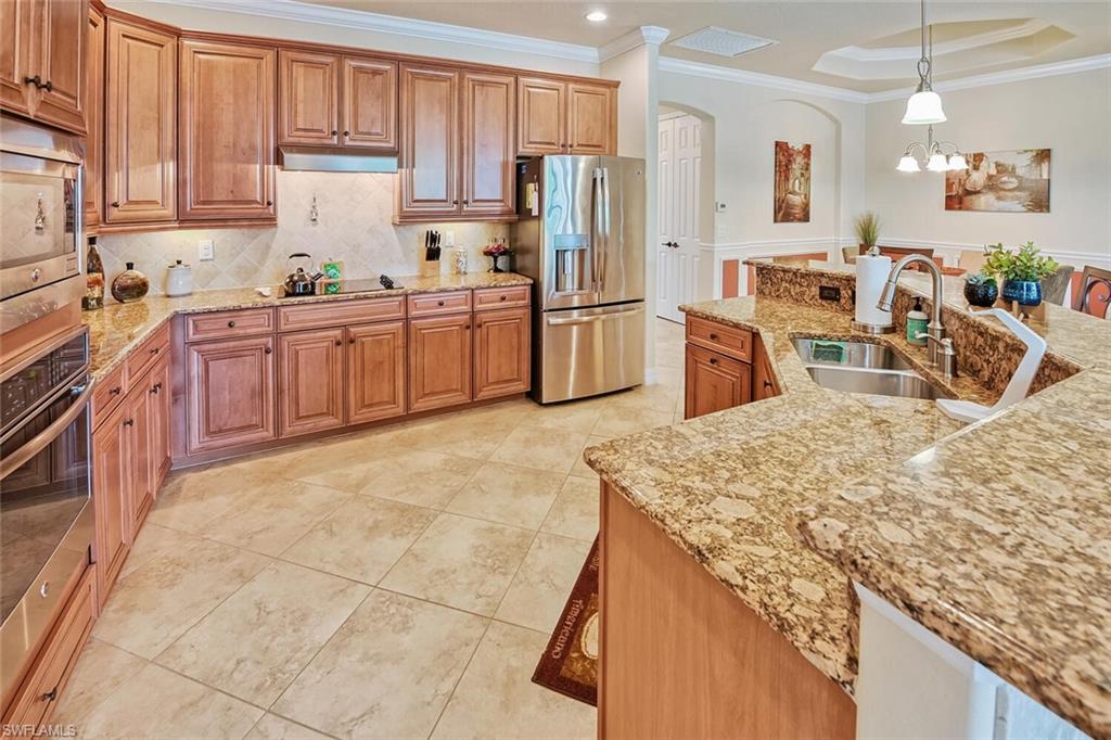 9415 Piacere Way Naples, FL 34113 - Photo 9 of 35 a kitchen with stainless steel appliances granite countertop a sink counter space and cabinets