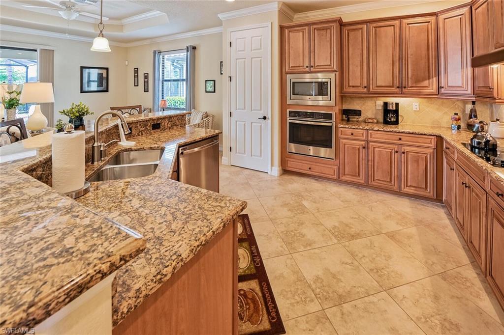 9415 Piacere Way Naples, FL 34113 - Photo 10 of 35 a kitchen with stainless steel appliances granite countertop a stove a sink and a microwave