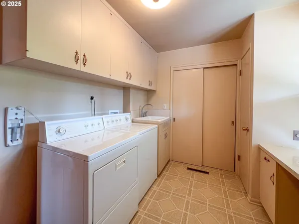 a utility room with cabinets washer and dryer