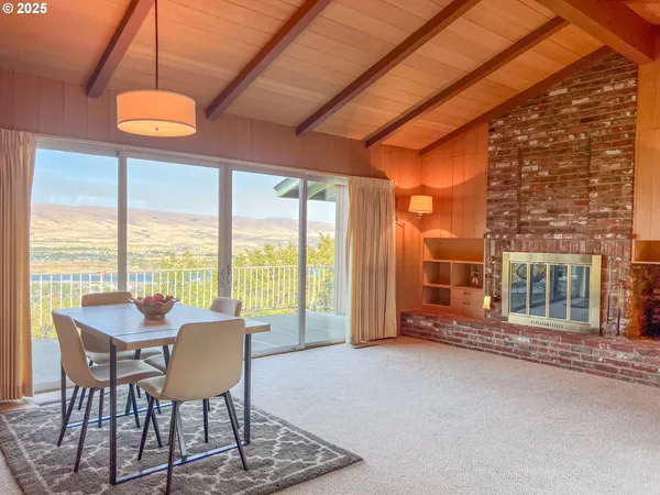 a dining room with furniture water view and a floor to ceiling window