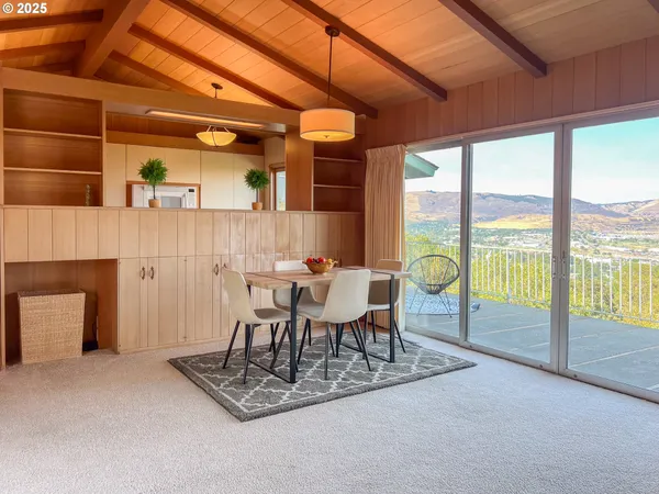 a dining room with furniture and a floor to ceiling window