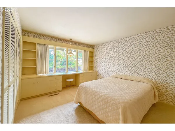 a bedroom with a bed and a large window