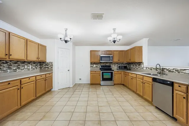 a large kitchen with a stove a sink dishwasher and a refrigerator