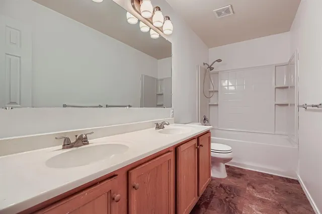 a bathroom with a sink a toilet a mirror and shower