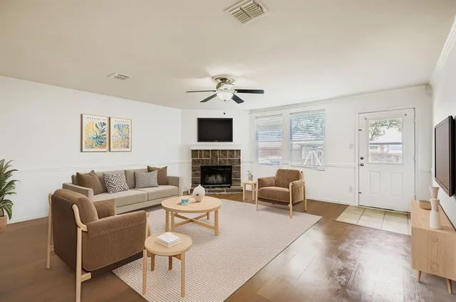 a living room with furniture a fireplace and a large window