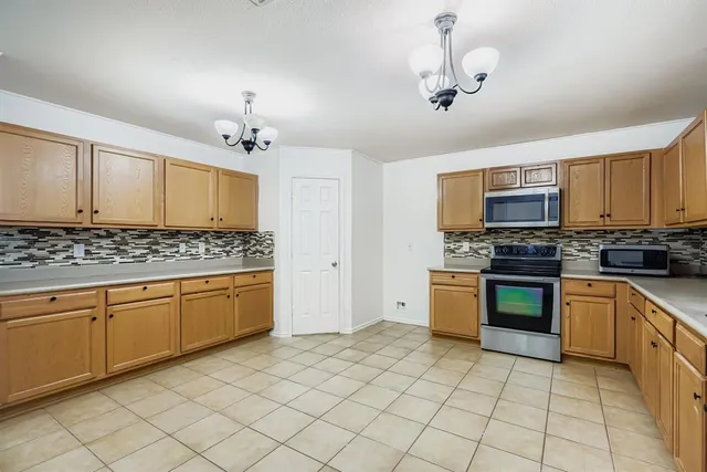 a kitchen with granite countertop a sink stainless steel appliances and cabinets