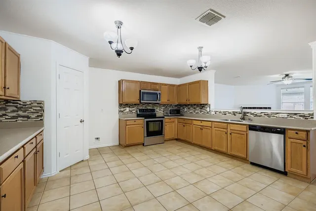a large kitchen with cabinets and stainless steel appliances