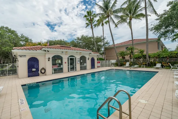 a view of a backyard with swimming pool and sitting area