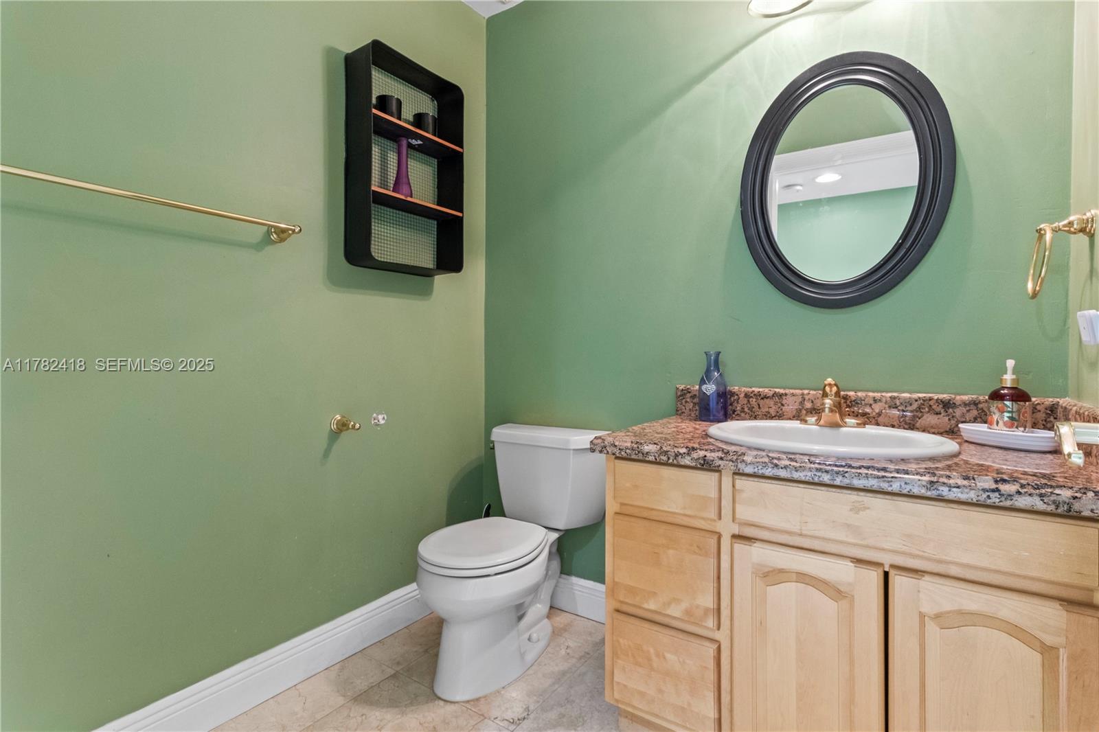 8350 Southwest 98th Street Miami, FL 33156 - Photo 12 of 67 a bathroom with a granite countertop toilet a sink and a mirror