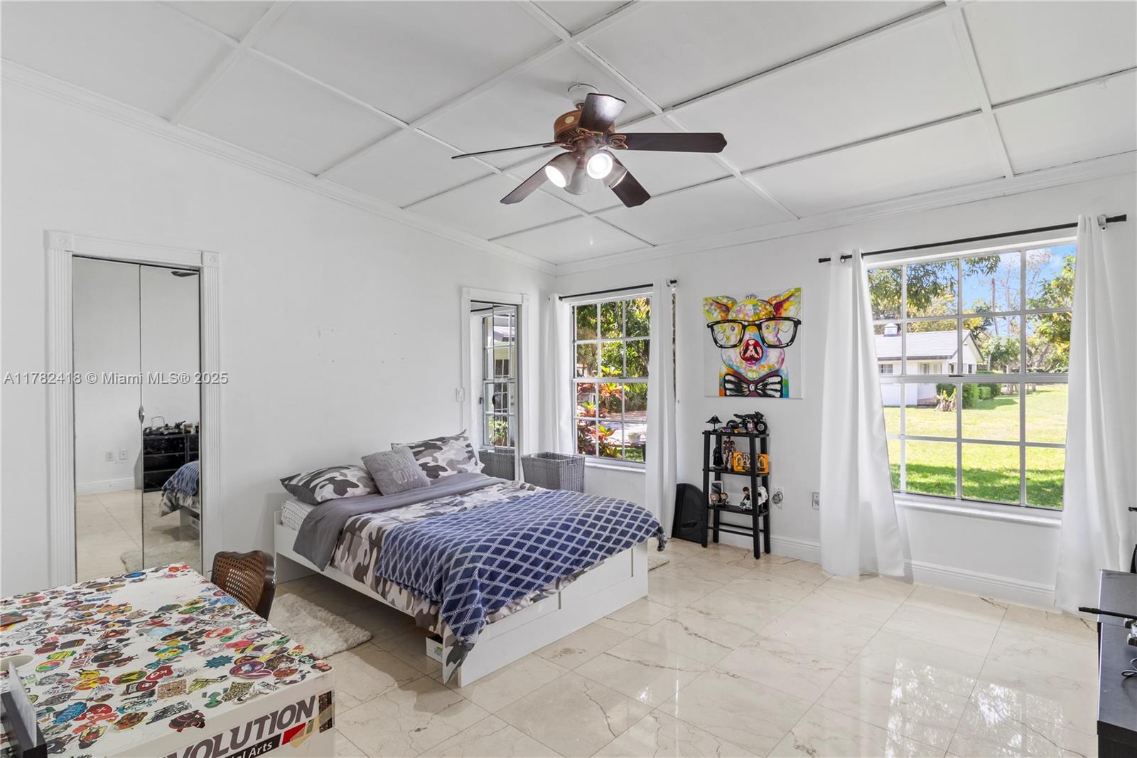 8350 Southwest 98th Street Miami, FL 33156 - Photo 18 of 67 a bedroom with a large bed and a chandelier fan