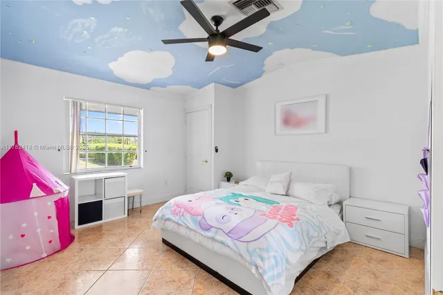 a spacious bedroom with a bed a couch and a large window