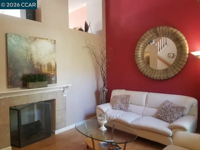 a living room with furniture a fireplace and a floor to ceiling window
