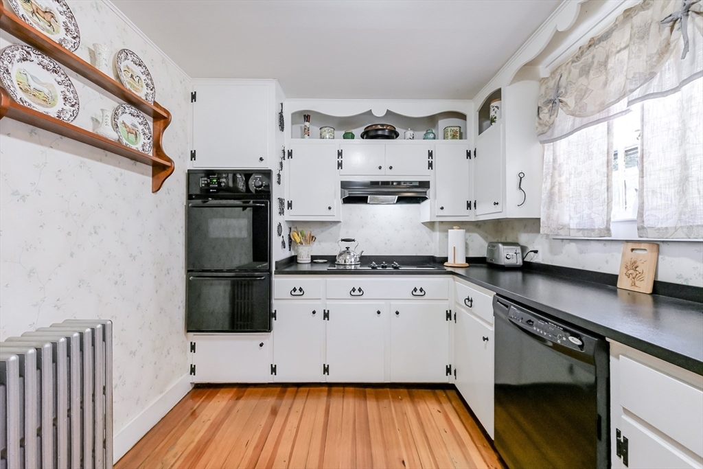 147 Shirley Street Pepperell, MA 01463 - Photo 17 of 42 a kitchen with stainless steel appliances white cabinets a sink a stove a refrigerator and wooden floor