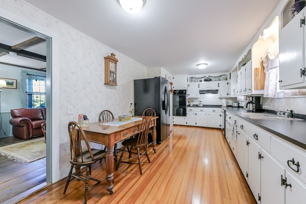 147 Shirley Street Pepperell, MA 01463 - Photo 19 of 42 a kitchen with stainless steel appliances a dining table chairs stove refrigerator and cabinets