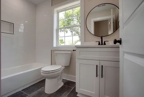 a bathroom with a toilet sink and mirror