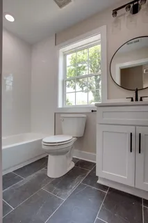 a bathroom with a toilet sink a mirror and bathtub