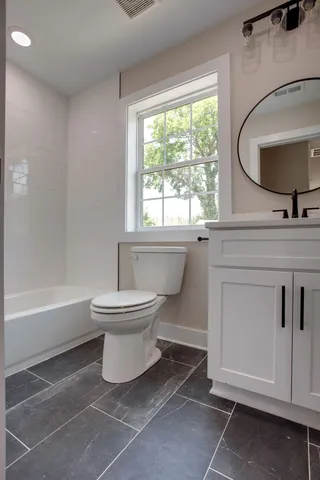 a bathroom with a toilet sink a mirror and bathtub