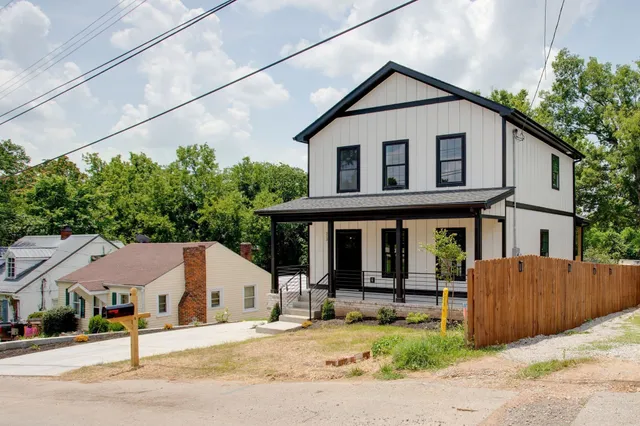 a white house that has a tree in front of it