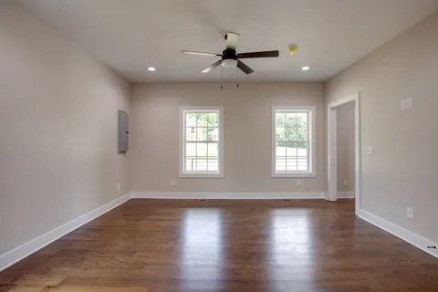 an empty room with wooden floor and windows