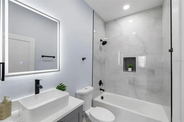 a bathroom with a sink toilet tub and shower