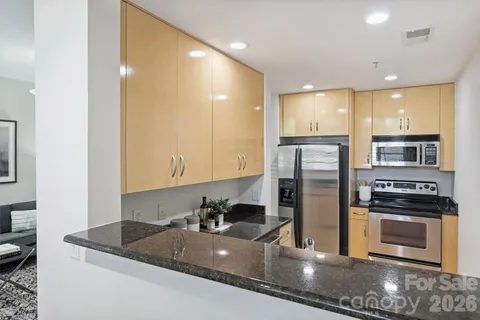 a kitchen with stainless steel appliances granite countertop a stove a sink and a refrigerator