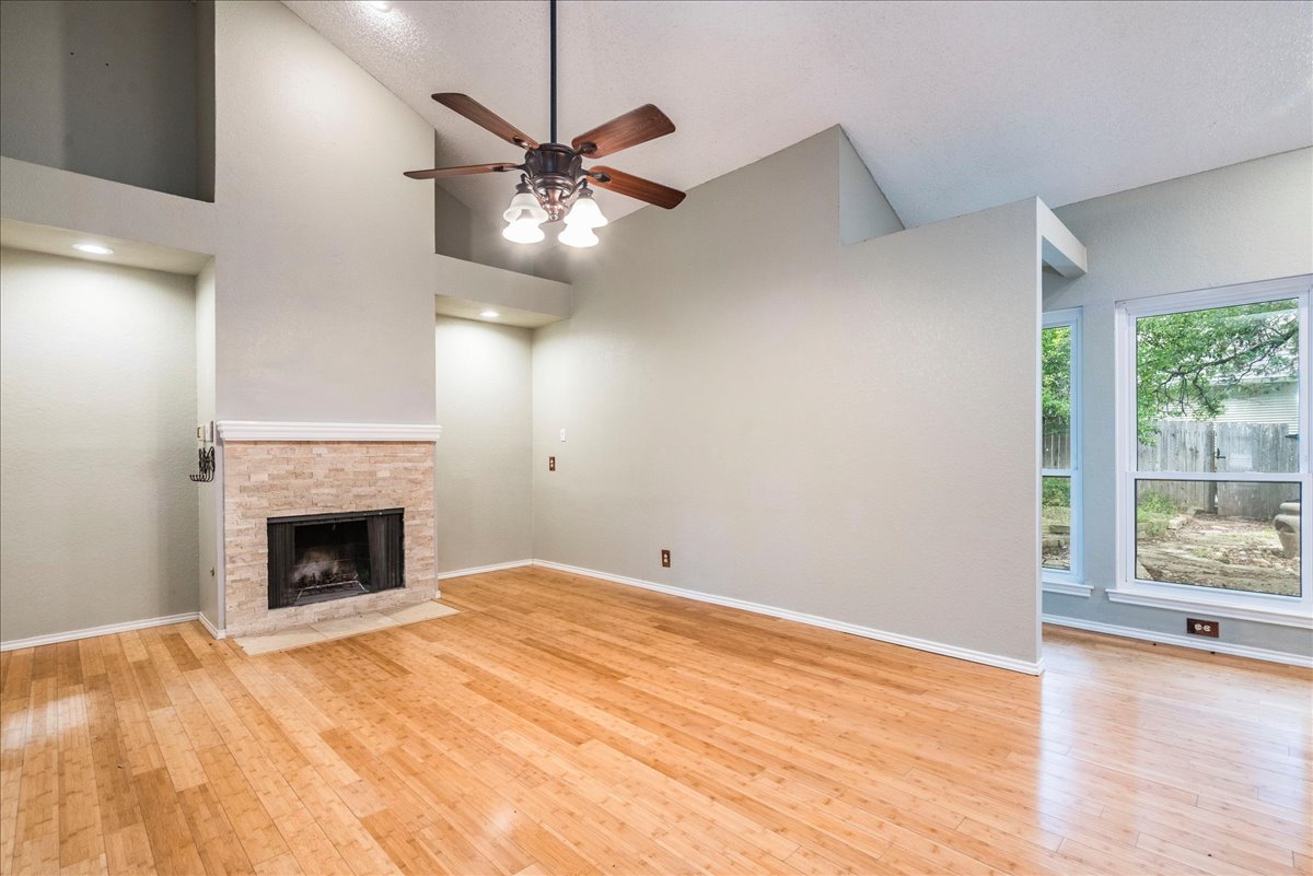 3809 Spicewood Springs Road, Unit 127 Austin, TX 78759 - Photo 6 of 29 A living space offers a fireplace, high ceilings, and ample natural light from generous windows.