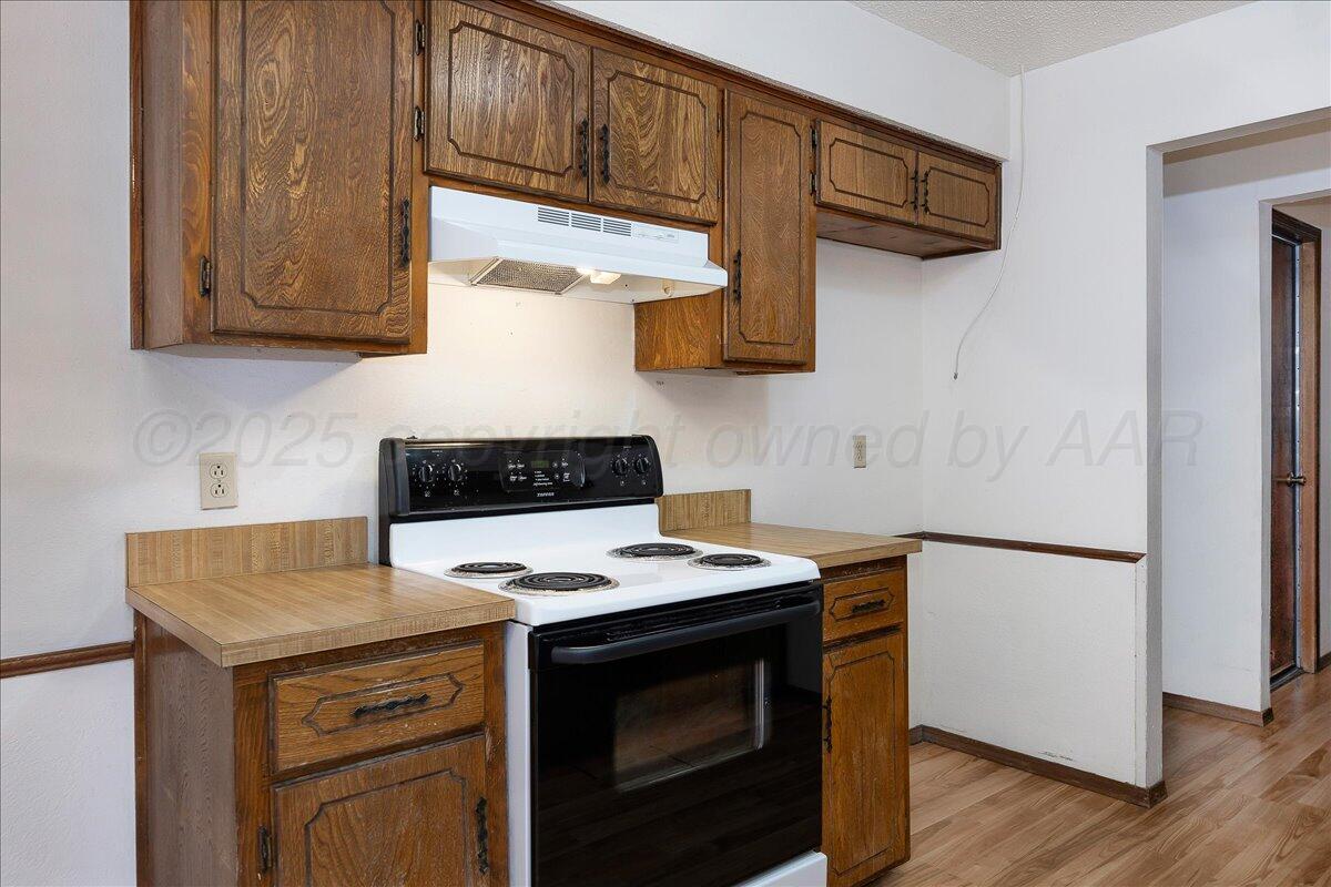 7210 Hatton Road Amarillo, TX 79110 - Photo 11 of 23 a kitchen with stainless steel appliances granite countertop a stove a microwave and a refrigerator