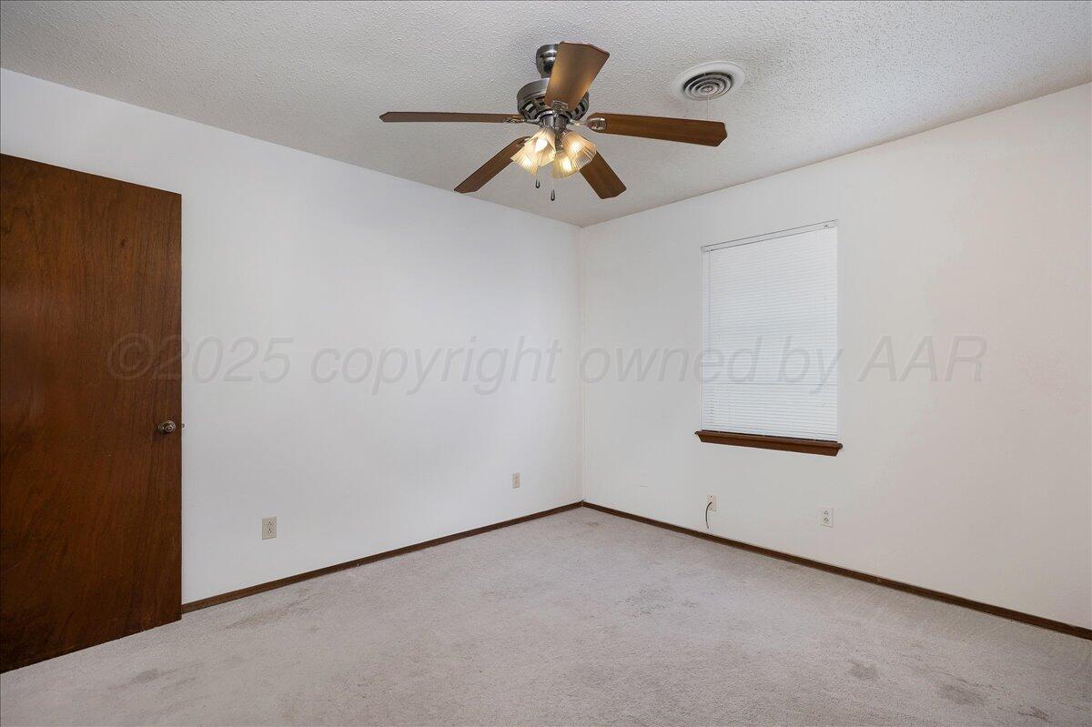 7210 Hatton Road Amarillo, TX 79110 - Photo 15 of 23 an empty room with ceiling fan and window