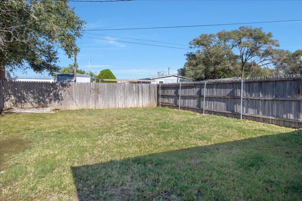 7210 Hatton Road Amarillo, TX 79110 - Photo 22 of 23 a view of a backyard with a small cabin and wooden fence
