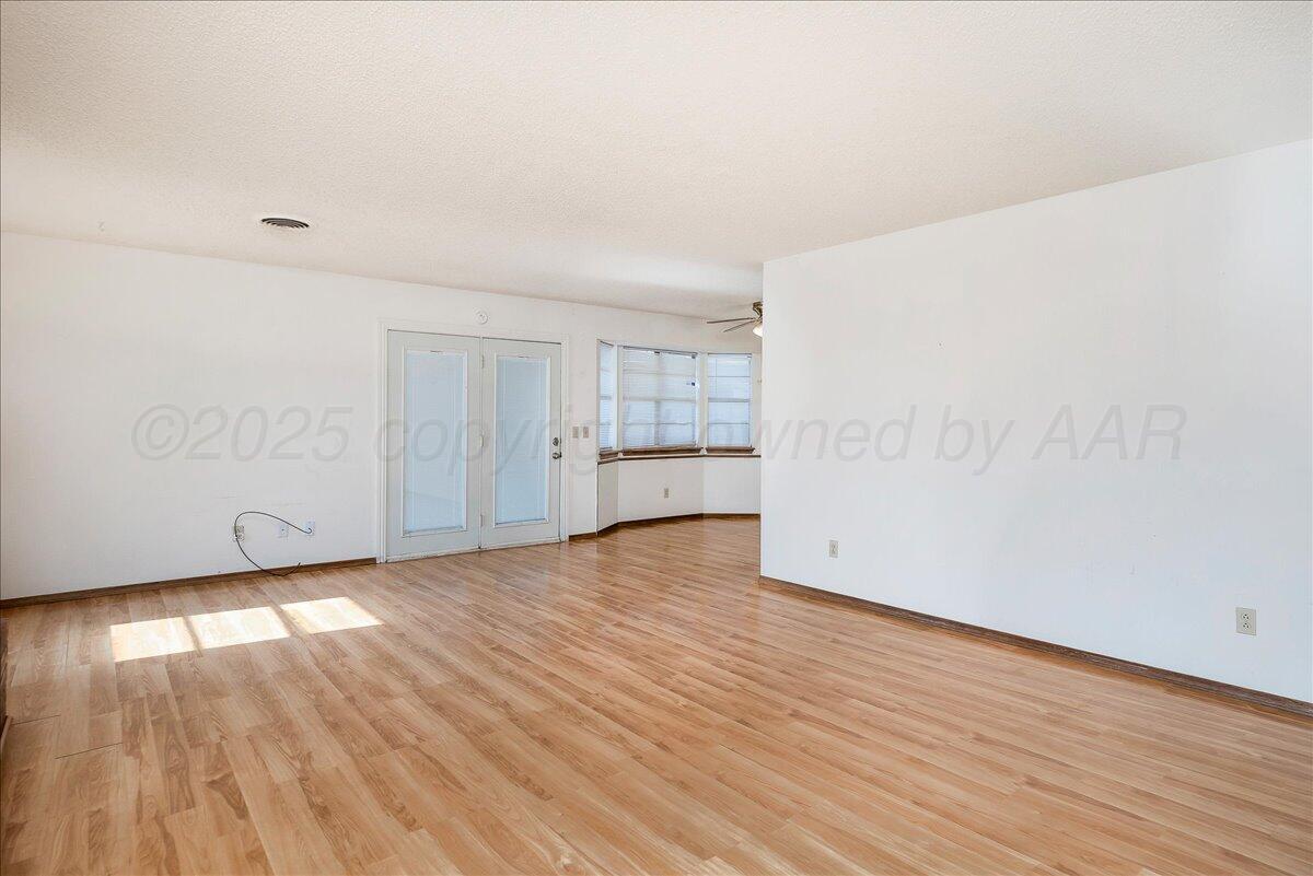 7210 Hatton Road Amarillo, TX 79110 - Photo 6 of 23 a view of an empty room with wooden floor and a window