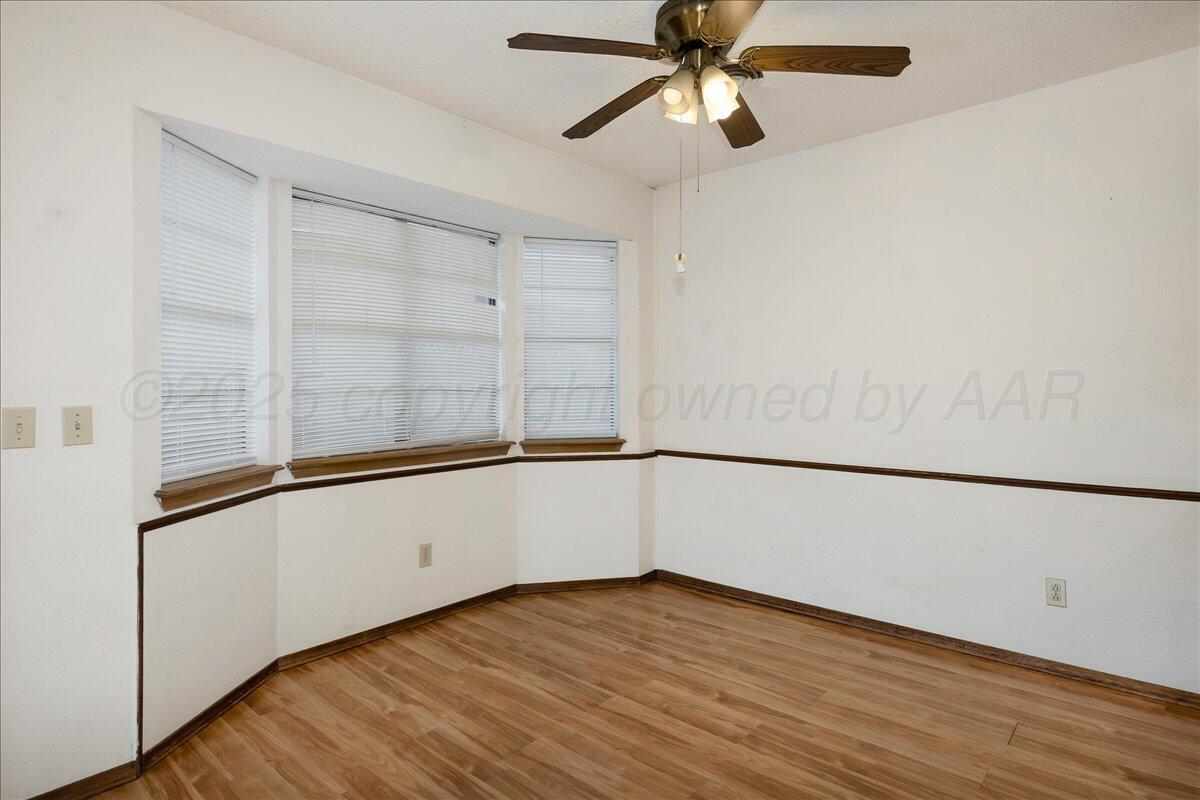 7210 Hatton Road Amarillo, TX 79110 - Photo 7 of 23 a view of an empty room with wooden floor and a window