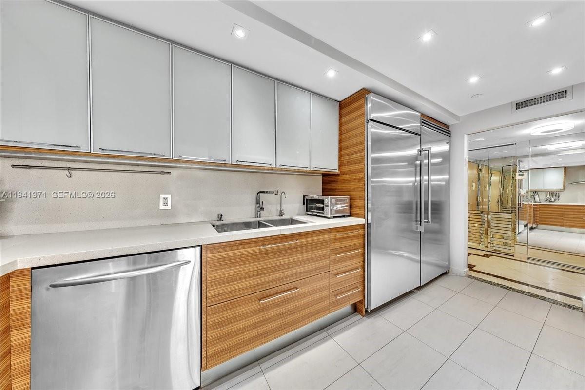 8877 Collins Avenue, Unit PH2 Surfside, FL 33154 - Photo 13 of 52 a kitchen with stainless steel appliances a refrigerator sink and cabinets
