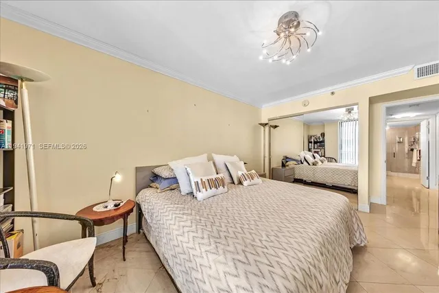 a spacious bedroom with a bed a table and a large window