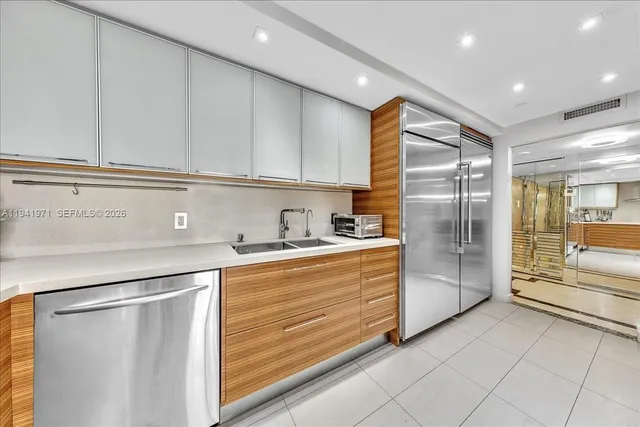 a kitchen with stainless steel appliances a refrigerator sink and cabinets