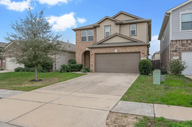 a front view of a house with a yard and garage