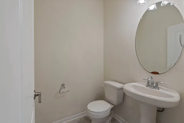 a bathroom with a sink toilet and a mirror