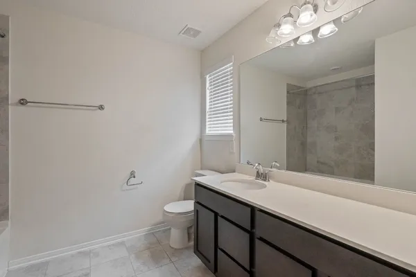 a bathroom with a sink a toilet and a mirror