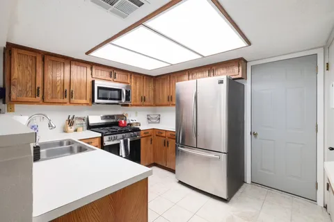 a view of a kitchen with a refrigerator a microwave and a sink